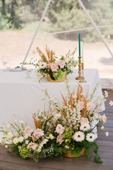 Coziness and style. Modern event design. Table setting at wedding reception. Floral compositions...