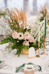 Coziness and style. Modern event design. Table setting at wedding reception. Floral compositions...