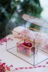 Modern wedding jewelry. Closeup of two wedding rings in a vintage box with flower petals.