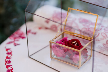 Modern wedding jewelry. Closeup of two wedding rings in a vintage box with flower petals.