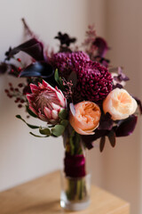 Beautiful modern bridal bouquet of colorful fresh flowers with silk ribbons. Classic wedding traditional accessory. Bride's  morning details.