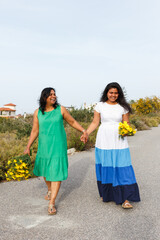 Mother and daughter walking holding hands outdoors