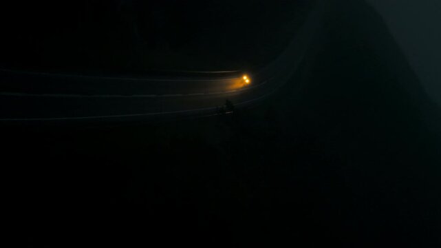 Peaceful nighttime setting with warm streetlamp light casting shadows across empty countryside path