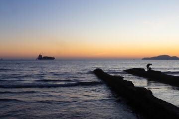 Sunset at Canal 5 in Santos with cargo ship on the horizon