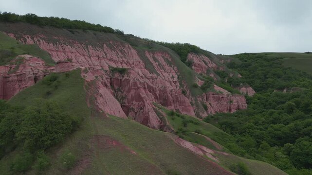 Dramatic aerial view of the Red Ravine, a unique geological monument with red clay formations in Romania