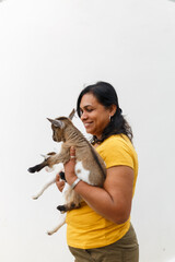 Woman holding happy baby goat smiling