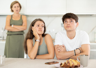 Mom make claims to young couple in home kitchen