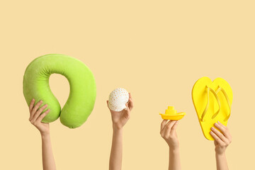 Female hands with travel pillow, flip-flops and toy boat on color background. International Women's Day