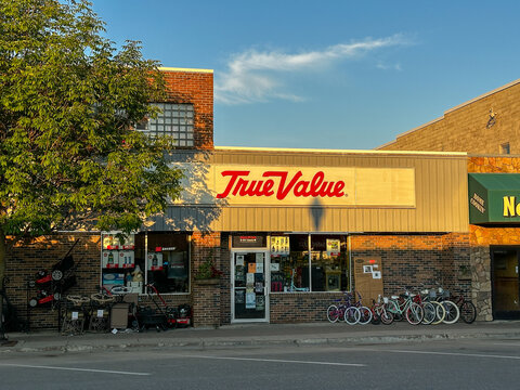 ROSEAU, MN - 21 JUL 2025: True Value hardware store front with a few items displayed on the sidewalk are seen in evening light.