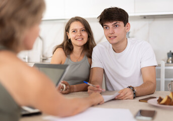 Obraz premium Married couple of clients listen attentively and intently to woman of seller, who tells about advantages of making microloan in credit institution