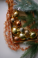 Old vintage Christmas ornaments golden walnuts in box with copper tinsel, top view