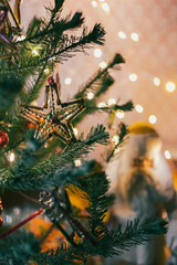 Branch of artificial Christmas tree decorated with old glass beaded ornament star, holiday background, selective soft focus
