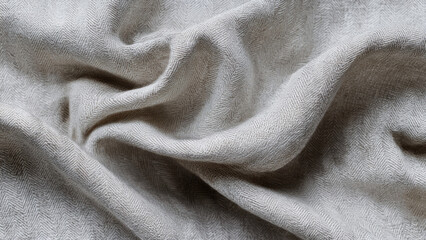 Fototapeta premium A close-up of a soft, light grey fabric with a classic herringbone weave pattern, gently draped and textured, showing elegant folds and subtle shadows.