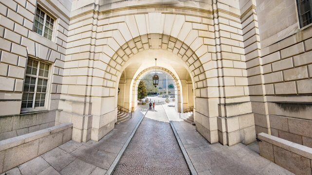 Travel destination architecture in Washington, D.C. Symmetrical archway leading through classical stone buildings.