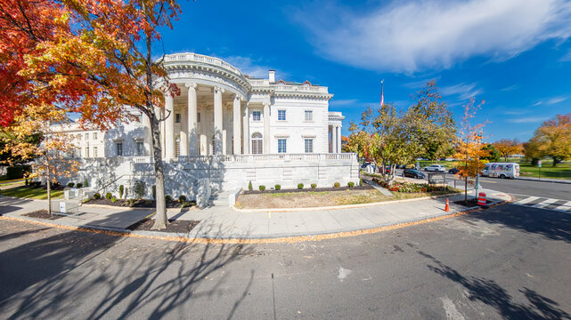 neoclassical building with white columns in downtown Washington, D.C., during a colorful autumn day.