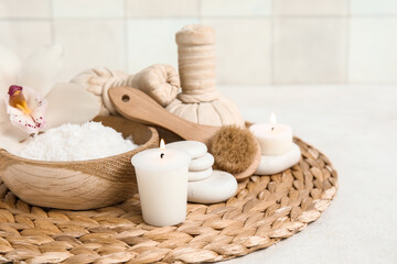 Sea salt with herbal bags, spa stones, orchid flower and burning candles on white table