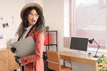 Shocked female African-American spy with folder in office