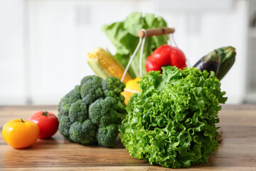 Different fresh vegetables on wooden kitchen counter, closeup