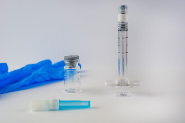 glass syringe and blue medical glove on white table surface close up of cosmetic injection equipment with copy space for banner design concept of aesthetic medicine, dermatology, plastic surgery