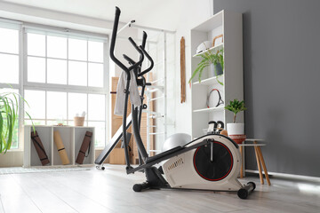 Modern elliptical machine in light gym
