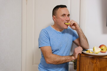 Man eating apple while using mobile phone against white background. a man eats a pear