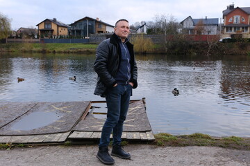 Rear view of man standing and holding camera by Lake Stellisee with Matterhorn mountain and blue...