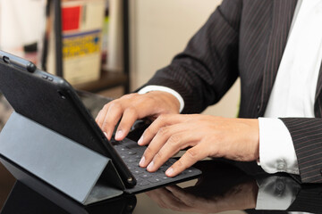 a male hands of a business man working on a tablet keyboard