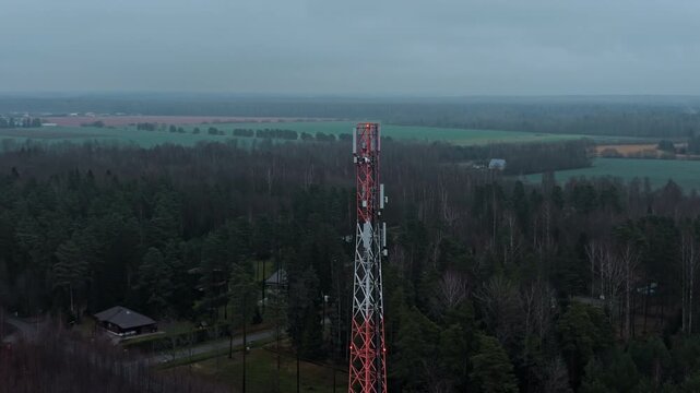 Elevated view of communication tower, Highaltitude shot emphasizing tall antenna among leafy treetops