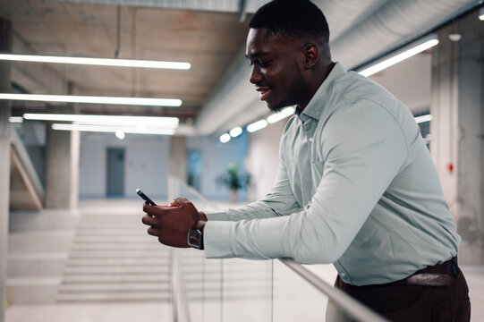 African american businessman using smartphone in modern office