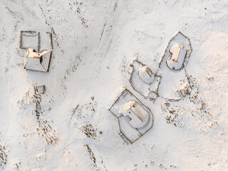 defaultExtreme overhead view of the snow-covered traditional 'Preskar' and 'Grapar' herdsmen's huts on Velika planina, showing their unique, oval-shaped roofs contrasting with the white ground