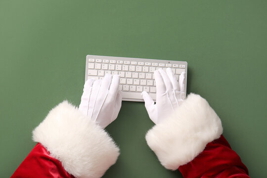 Fototapeta Santa Claus hands with keyboard on green background