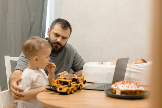 Lifestyle moment of fatherhood. Caucasian male adult caring for child and baby in home setting