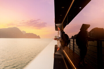 Scenic view of Halong bay at sunset with female in traditional hat