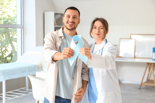 Young man and female urologist with blue ribbon in clinic. Prostate cancer awareness concept