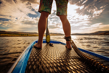 Woman exercising fitness on a stand up paddle board SUP in a big lake water in the Gunnison Valley, Crested Butte, Colorado. Relaxing and mindful © Justin