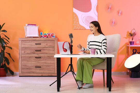 Young woman with clipboard recording podcast in studio