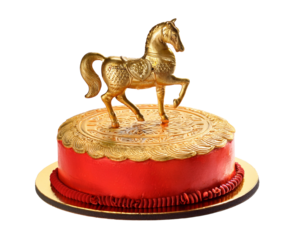 indian Gao cake decorated with golden horse topper, white background.