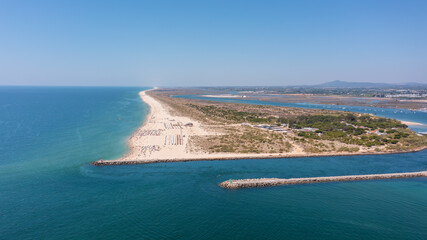Aerial view of serene beach landscape with golden sand and turquoise waters, showcasing natural beauty and tranquility in coastal environment. Tavira Portugal Algarve
