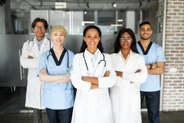 Multiracial professional team of newest modern clinic or hospital having breefing, happy doctors...