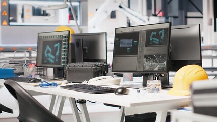 Monitors in photovoltaics factory used to manage performance of robot arms placing solar panels on assembly lines. PC screen in empty facility used for upgrading solar cell machinery.
