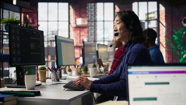 Technical support specialist in call center office troubleshooting customer connectivity issue through step by step guidance using headset and computer workstation, camera B