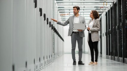 Two IT Professionals in Data Center Discussing Server Racks with Laptop - Powered by Adobe