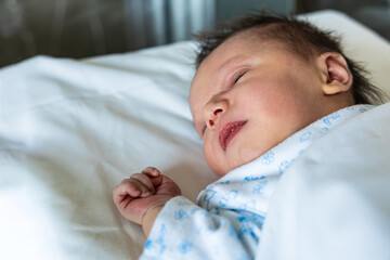 Newborn baby sleeping peacefully in hospital crib
