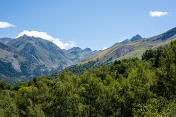 Obraz premium Majestic mountain landscape with lush greenery and blue sky on a sunny day