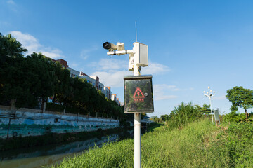 Numerous surveillance cameras are installed in a park in Dongguan City, Guangdong Province, and warning signs are erected along a road.
