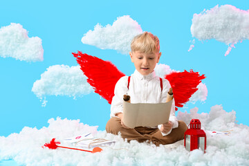 Fototapeta premium Cute little happy boy dressed as cupid with love letters and scroll sitting in clouds on blue background. Valentine's Day celebration