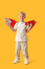 Obraz premium Cute little happy boy dressed as cupid with letters and word LOVE on yellow background. Valentine's Day celebration