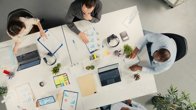Top down view of company staff engaged in a corporate event for business partnership, coworkers analyze targets and proposals, planning forecasts with stakeholders for investment.