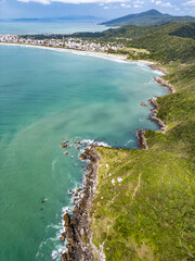 Aerial view of Bombinhas beaches with buildings, sand, rocks and forest