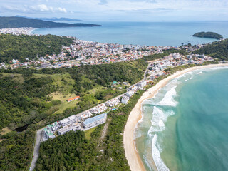 Aerial view of Bombinhas beaches with buildings, sand, rocks and forest